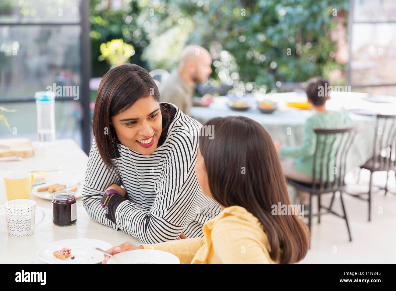 Mother and daughter talking, eating breakfast Stock Photo