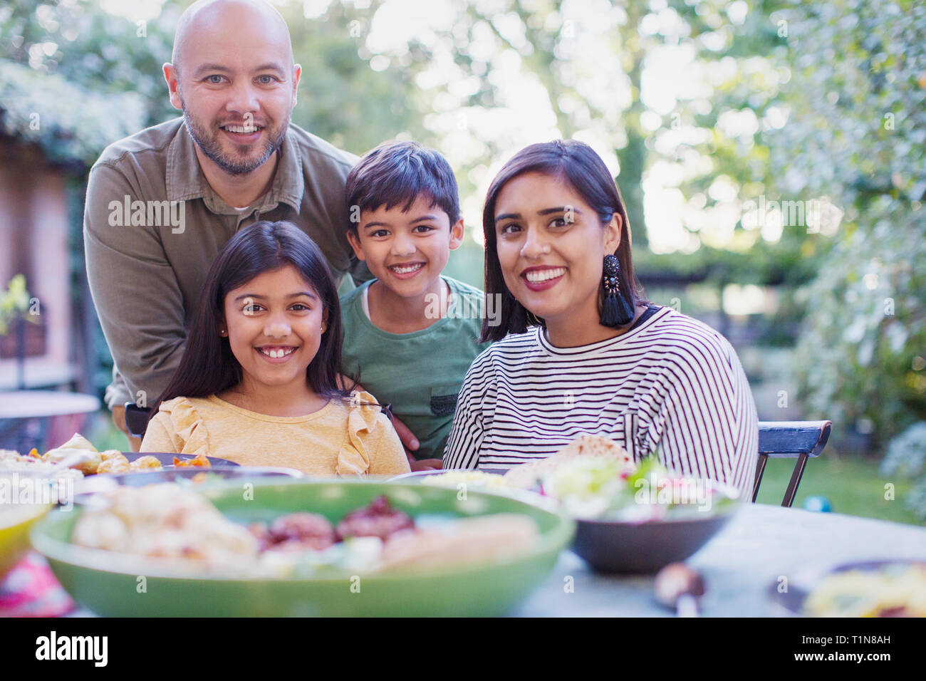 Portrait happy family eating lunch at table Stock Photo