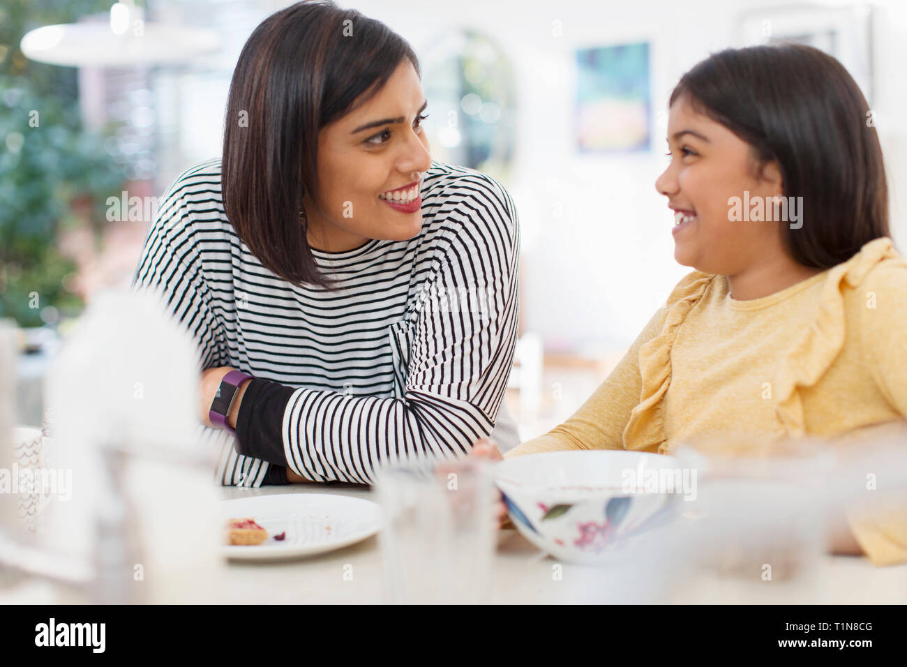 Happy mother and daughter eating breakfast Stock Photo