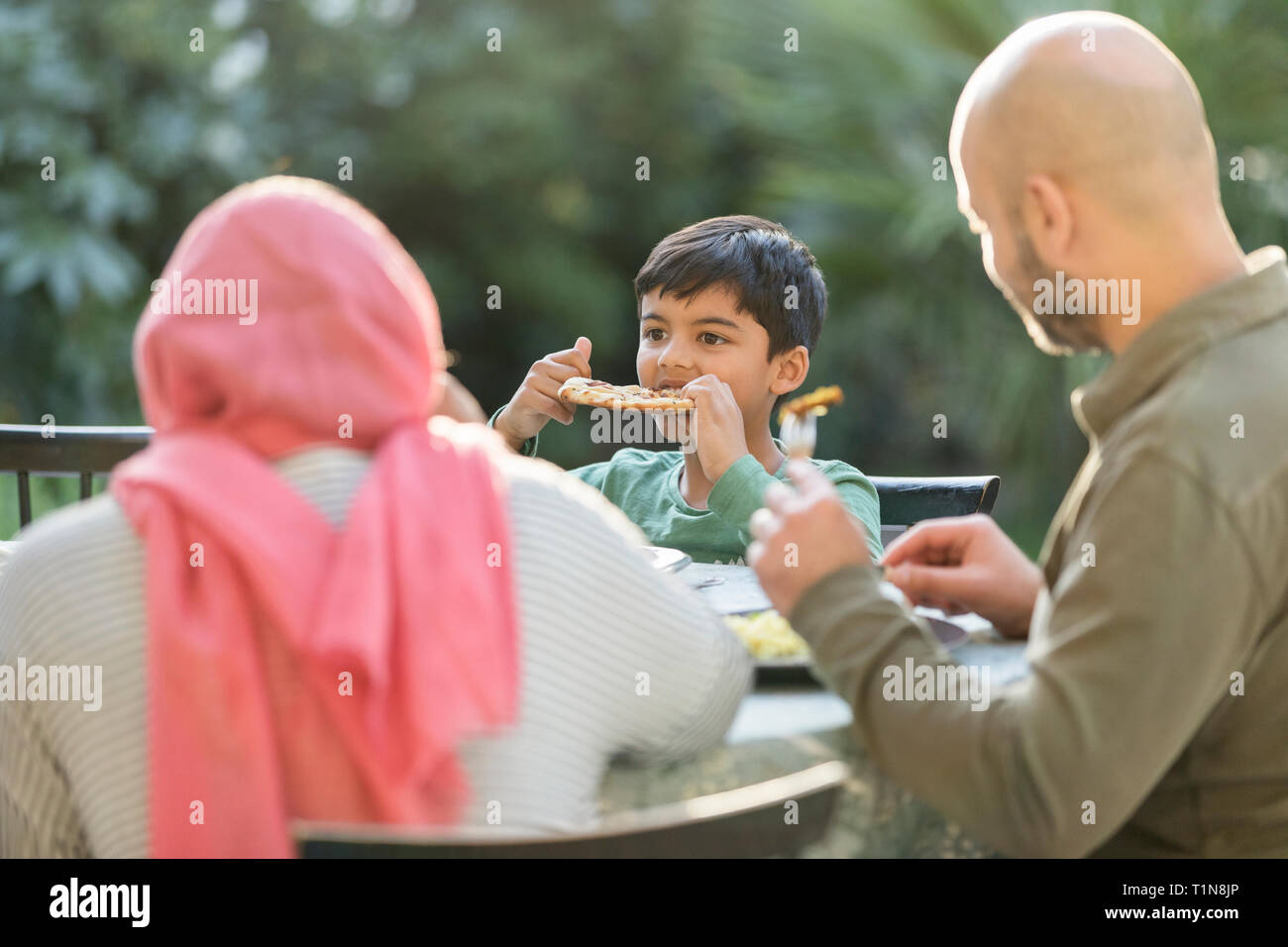 Family eating dinner at patio table Stock Photo
