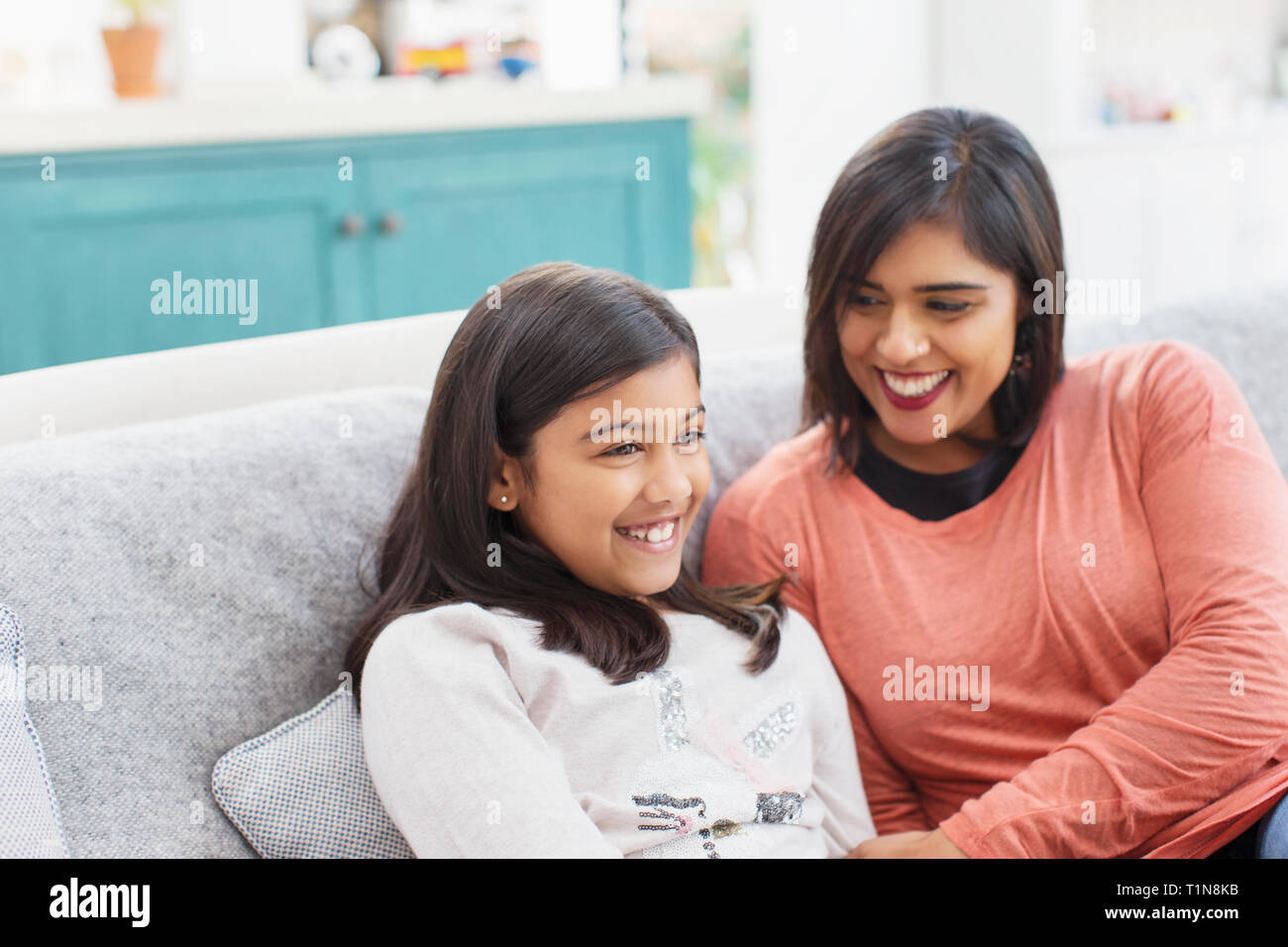 Happy mother and daughter on sofa Stock Photo