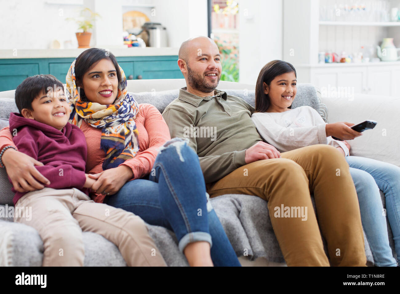 Family watching TV on living room sofa Stock Photo