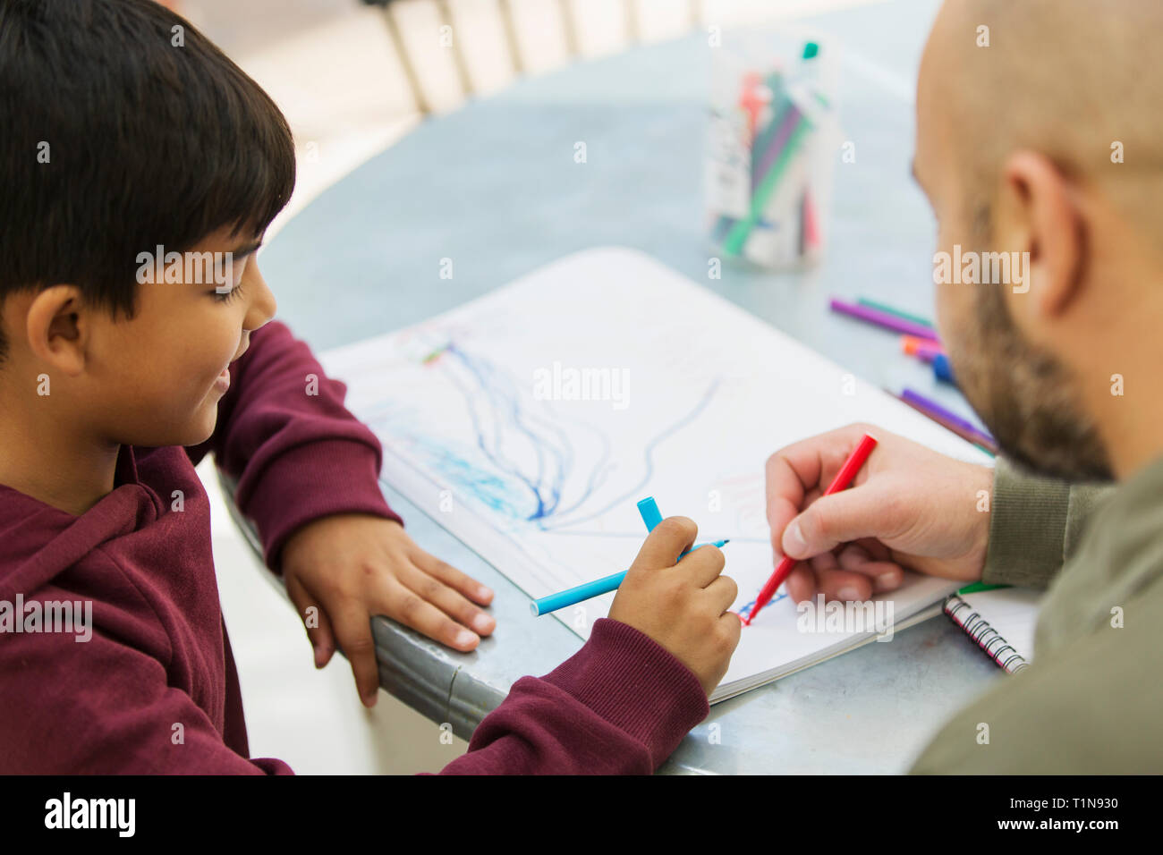 Father and son coloring at table Stock Photo