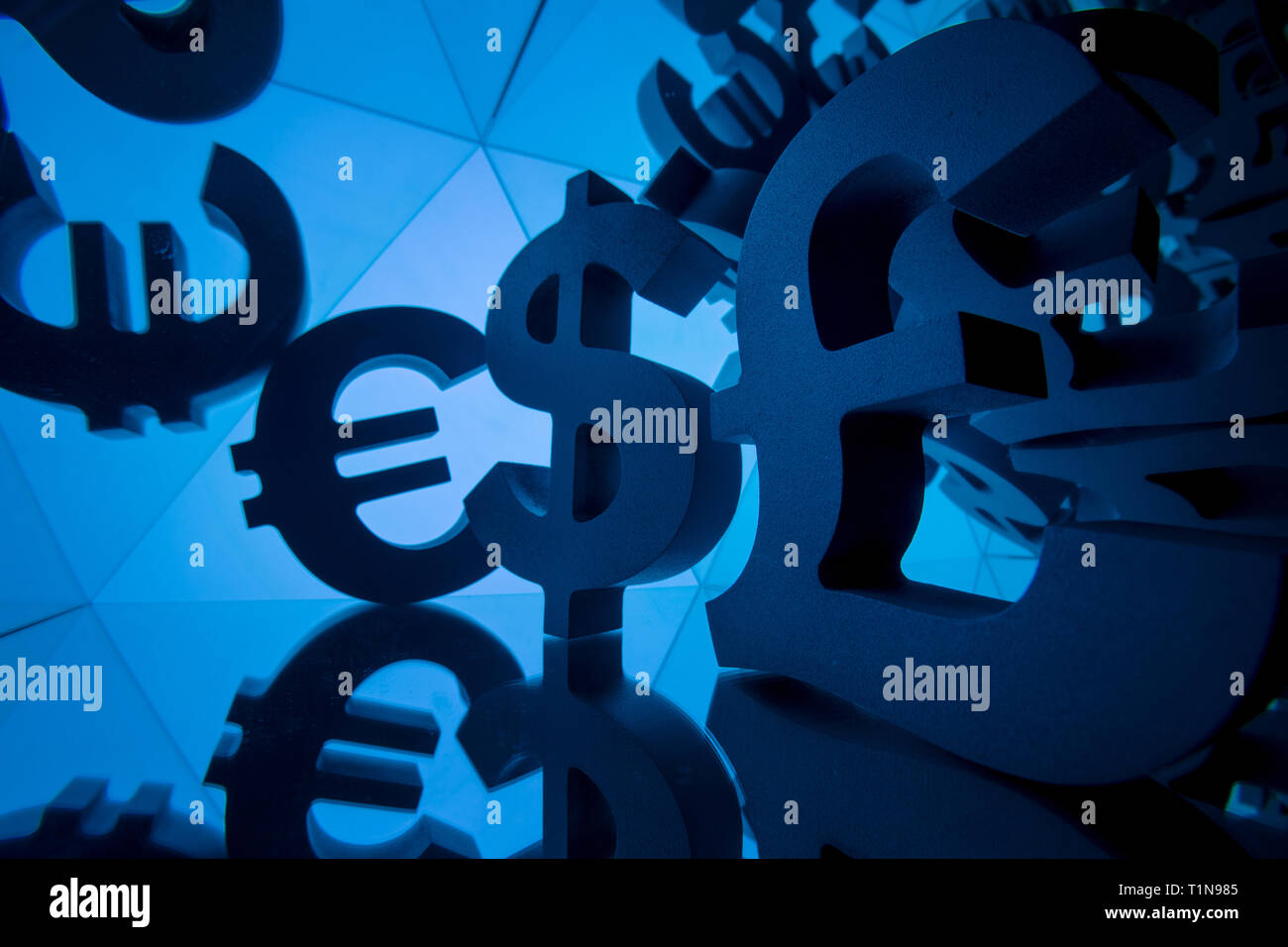 Euro, Pound and Dollar Currency Symbol With Many Mirroring Images of Itself on Blue Background Stock Photo