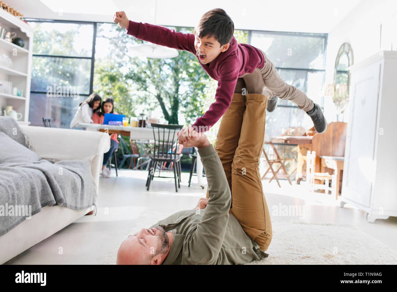 Father and son playing on living room floor Stock Photo