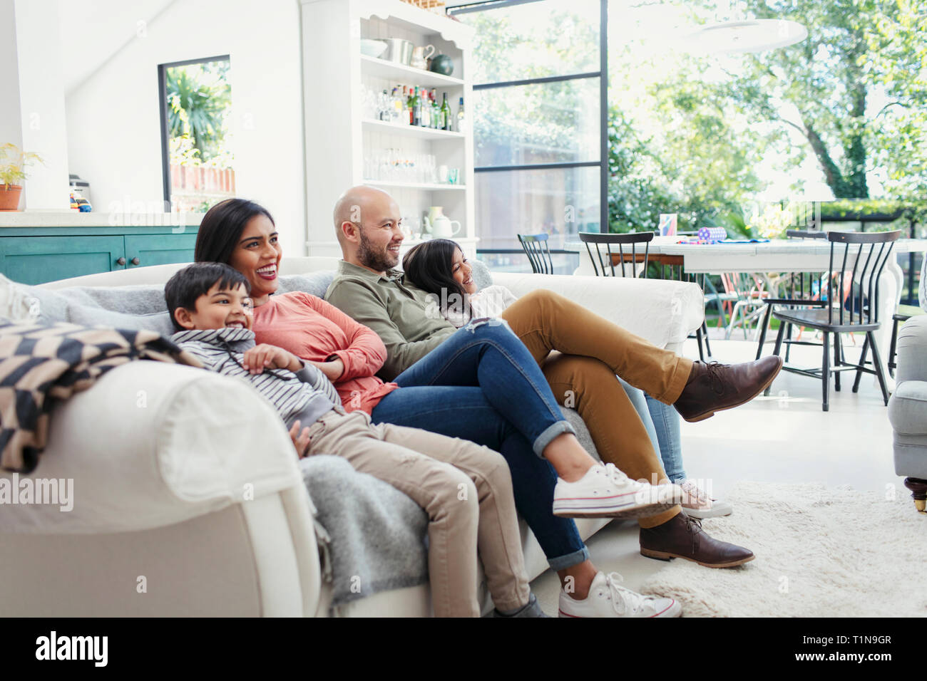 Family watching TV on living room sofa Stock Photo