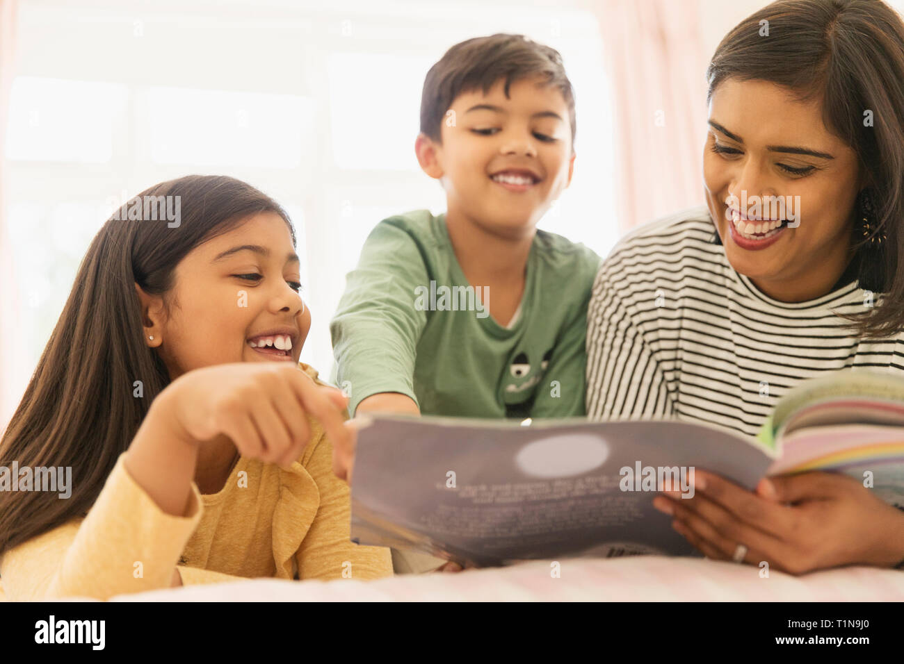 Mother and children reading book Stock Photo