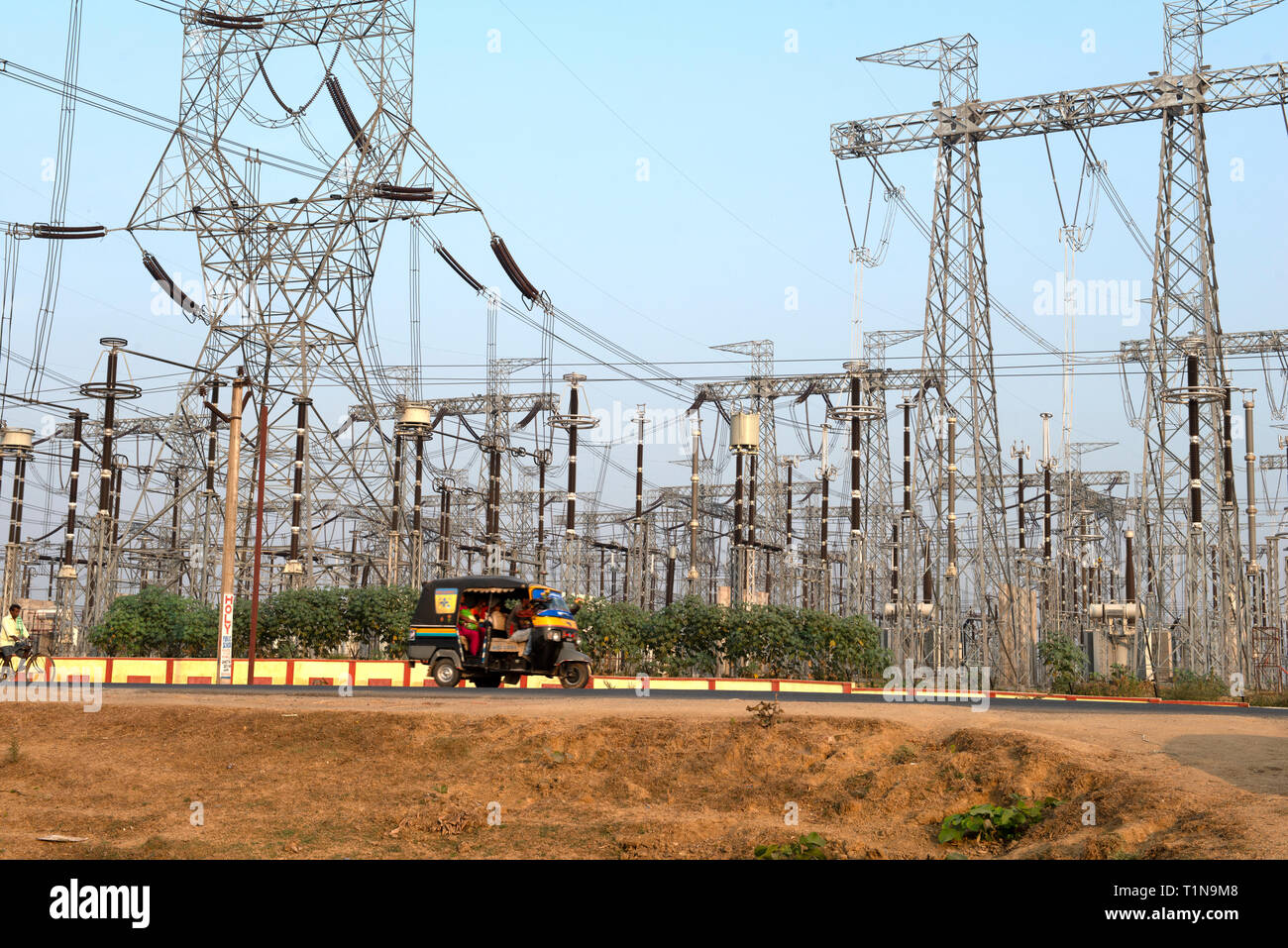 BODH GAYA, BIHAR, INDIA. November 27-2015. Tuk-Tuk Taxi passing a transformer station for a new high voltage line in rural India Stock Photo