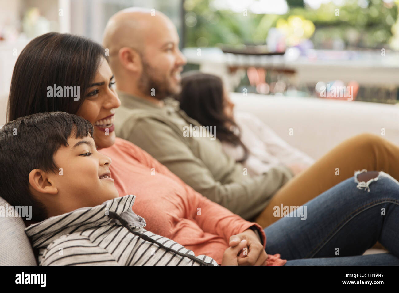 Family watching TV on living room sofa Stock Photo