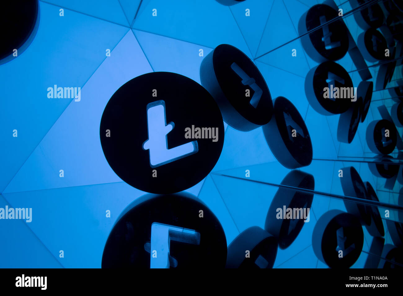 Litecoin Currency Symbol With Many Mirroring Images of Itself on Blue Background Stock Photo