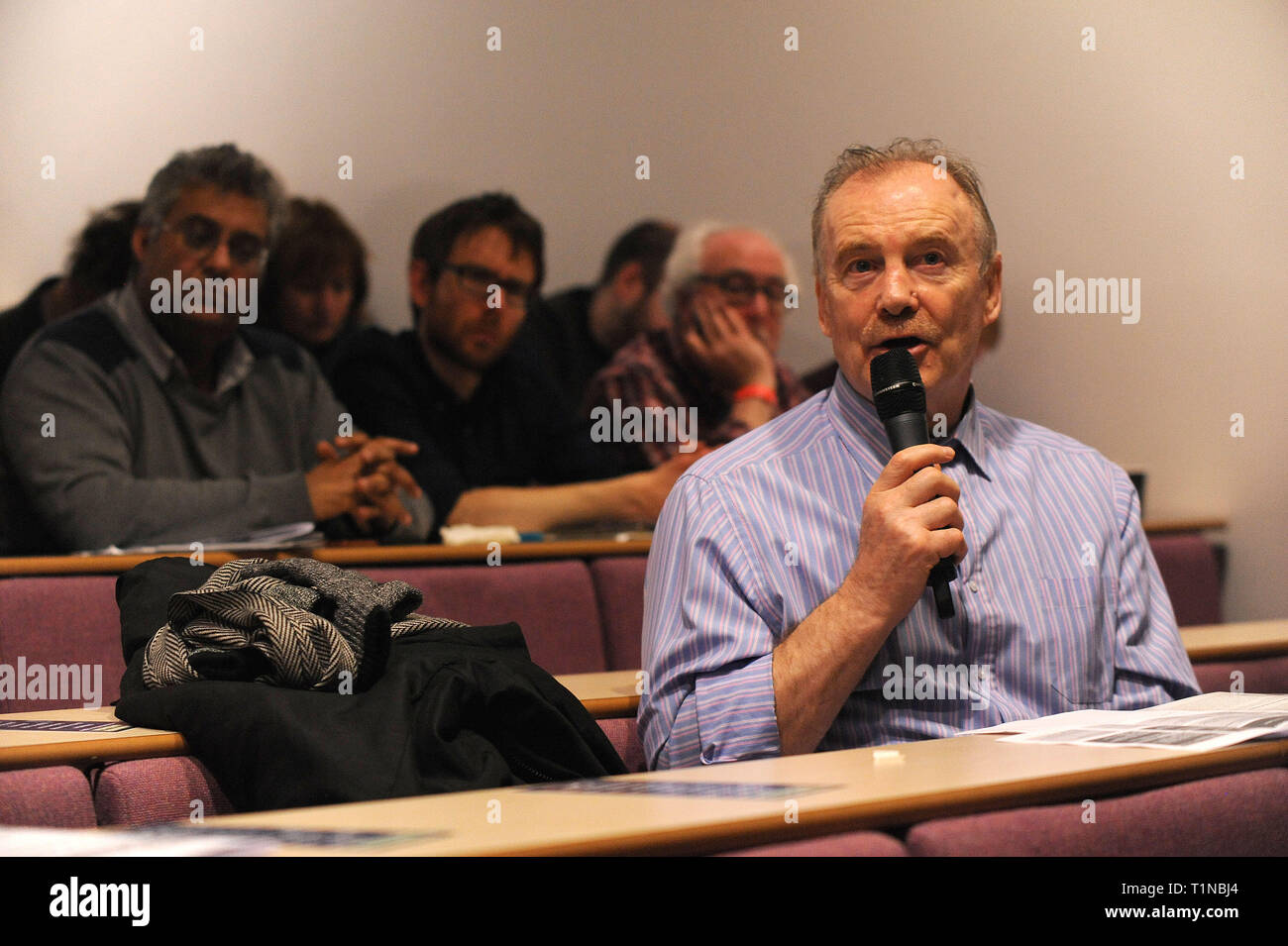 London, England. 16th March, 2019. A member of the audience puts a question to keynote speaker, Owen Jones, journalist, writer and activist, at the op Stock Photo