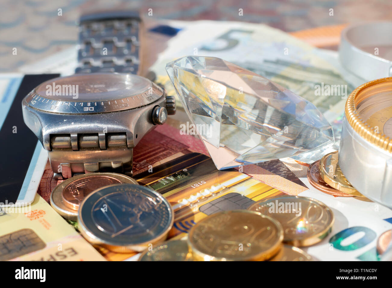 Signs of wealth: Euro banknotes, coins, credit card, jewelry, diamonds Stock Photo