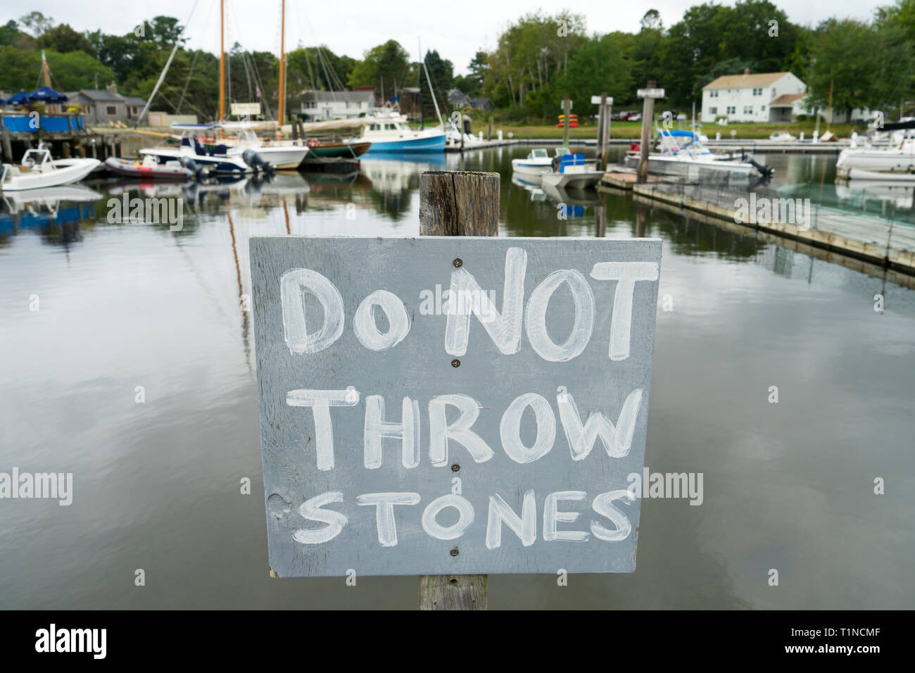 Hand painted sign warning people not to throw stones in Kennebunkport harbor, Maine, USA. Stock Photo