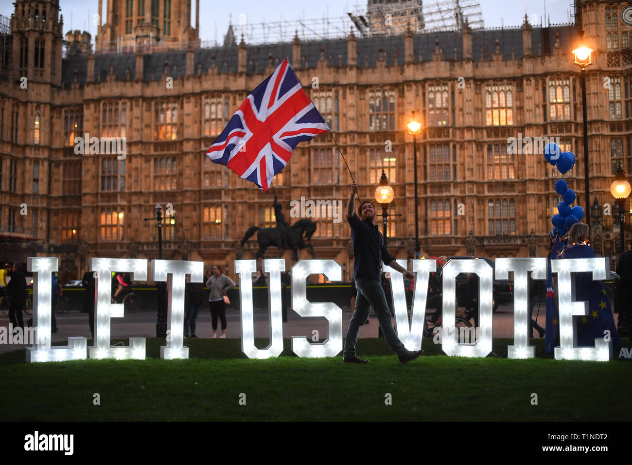 An Anti Brexit Protestor With An Illuminated Sign Reading Let Us Vote Outside The Houses Of Parliament London On The Day That Mps Will Be Asked To Consider A Range Of Alternative Brexit