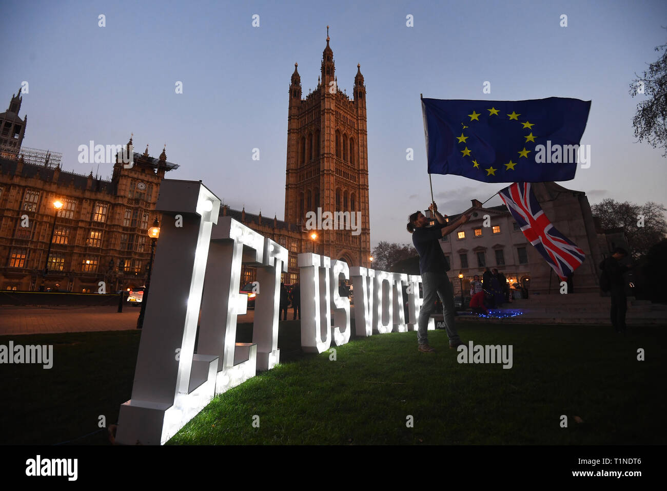 An Anti Brexit Protestor With An Illuminated Sign Reading Let Us Vote Outside The Houses Of Parliament London On The Day That Mps Will Be Asked To Consider A Range Of Alternative Brexit