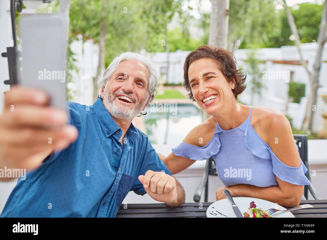 Mature couple taking selfie with camera phone on hotel patio Stock Photo