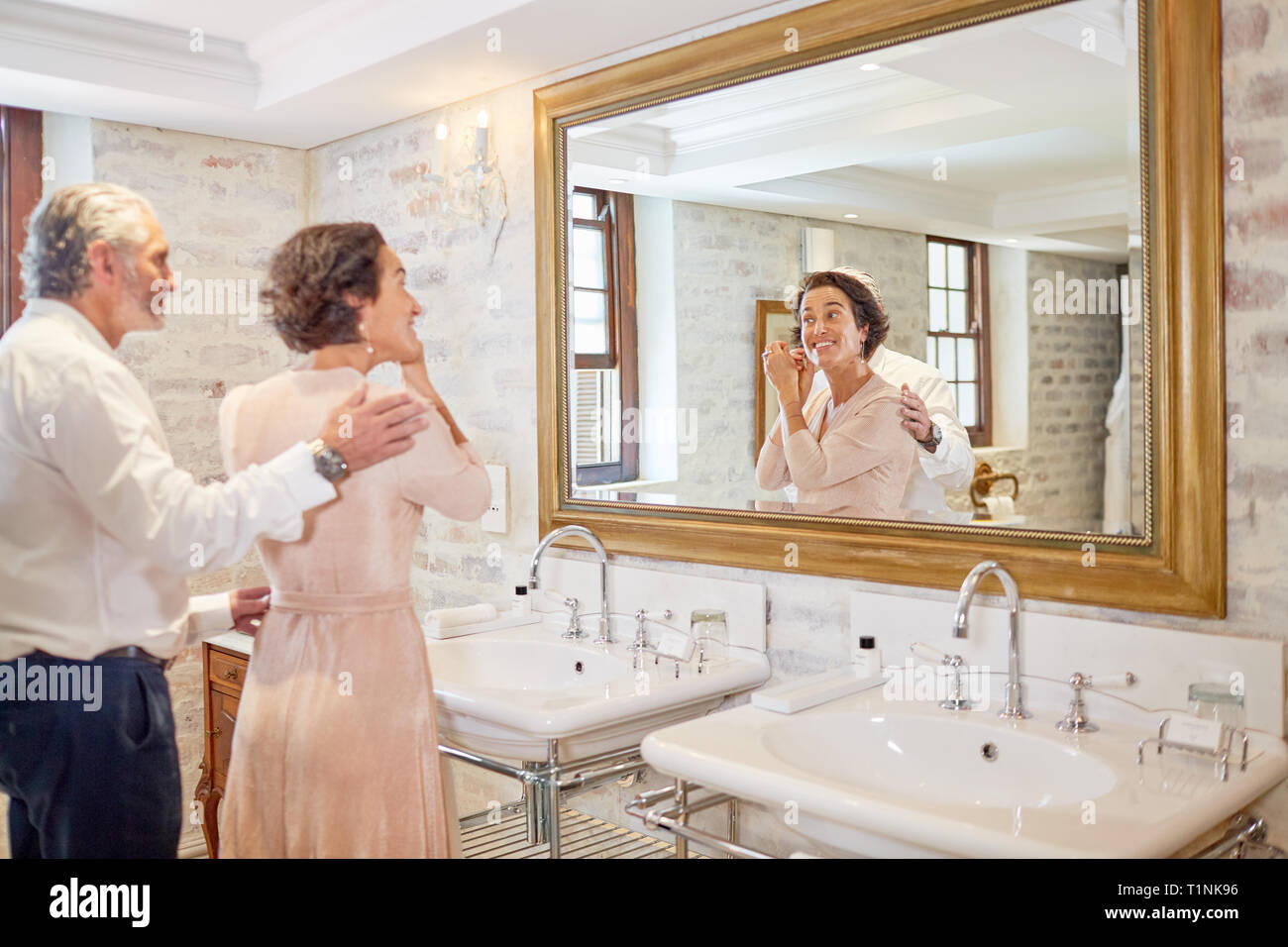 Couple getting ready in hotel bathroom mirror Stock Photo