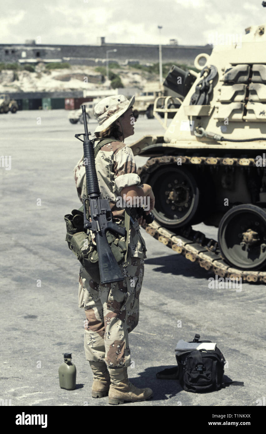 29th October 1993 A female New Zealand national, serving as a U.S. Army soldier, stands next to an M88 recovery vehicle, an M16A2 rifle over her shoulder, in the new port in Mogadishu, Somalia. Stock Photo