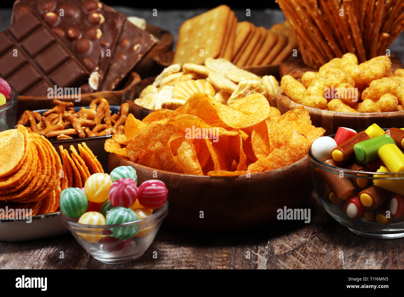 Salty snacks. Pretzels, chips, crackers in wooden bowls. Unhealthy
