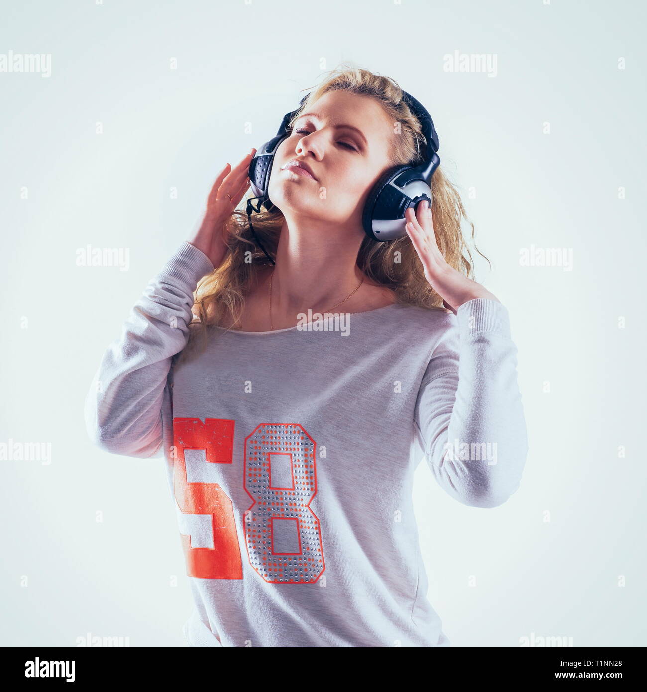 Happy cute young woman with headphones listening to music Stock Photo ...