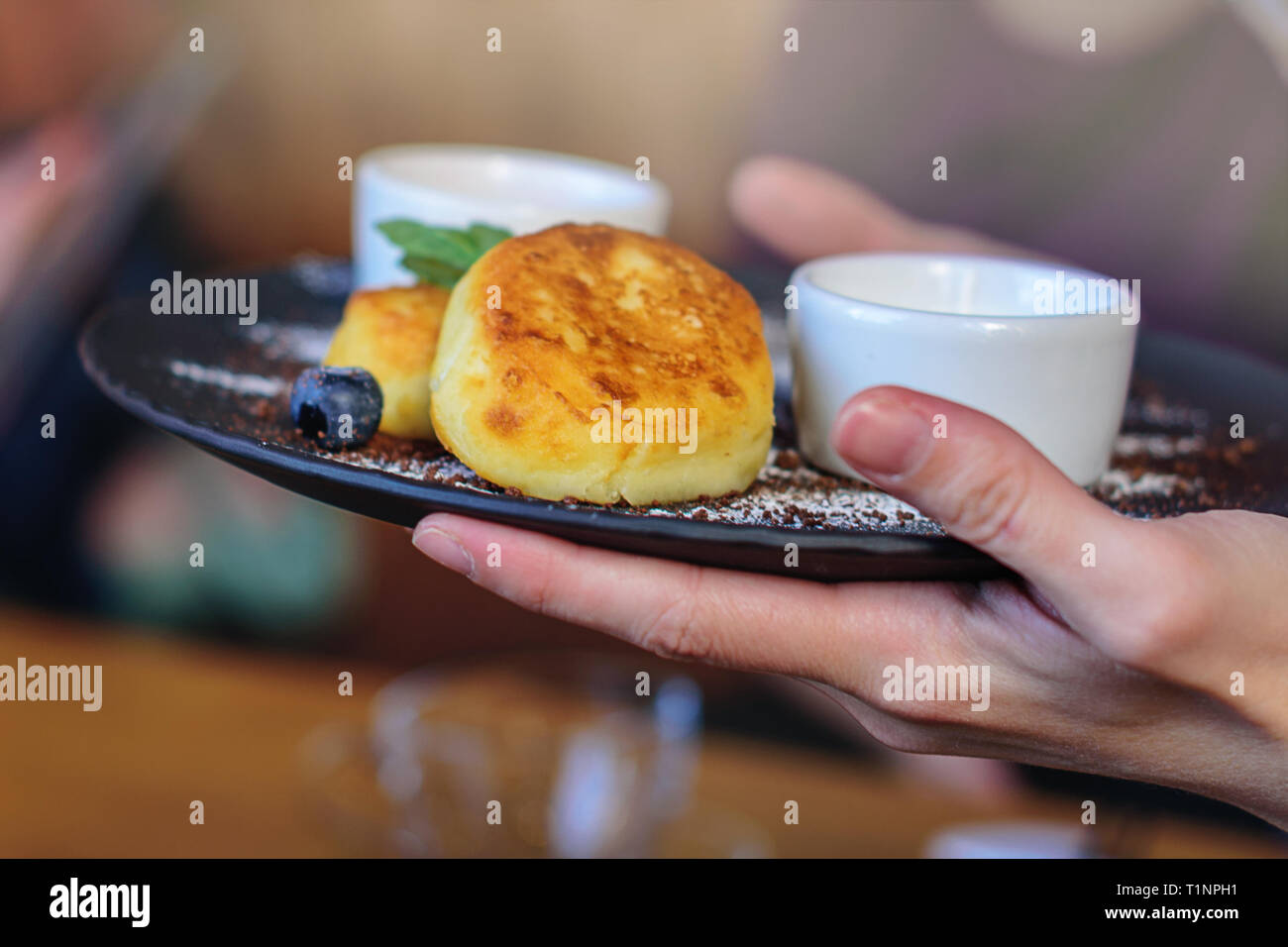 Cottage Cheese Pancakes With Blueberry And Mint For Breakfast Or Lunch Jam And Sour Cream The Girl S Hands Holding The Finished Dish Stock Photo Alamy