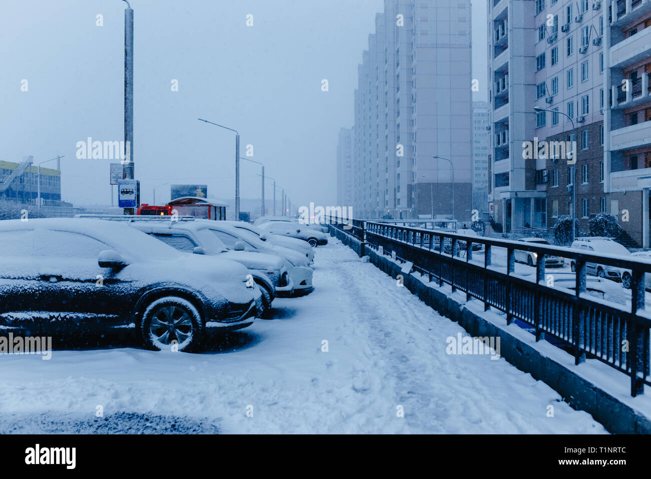 Winter snow city street scene. Snow covered cars on winter street in Russia. Stock Photo
