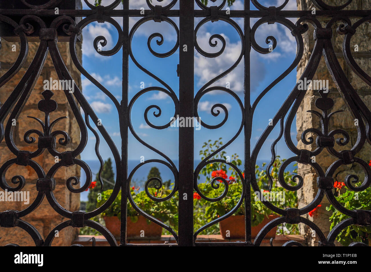 Wrought iron gate with sea and flowers in the background Stock Photo ...
