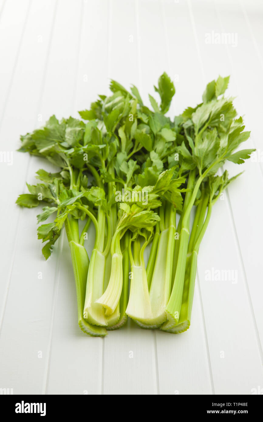 Bunch of fresh celery stalk on white table. Stock Photo