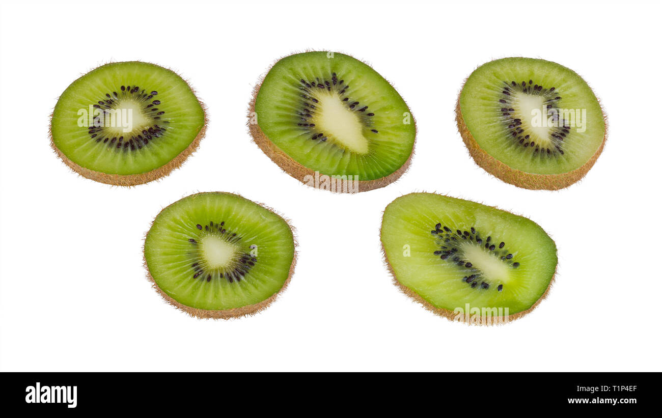 Green kiwi fruit slices. Fuzzy kiwifruit. Actinidia deliciosa. Isolated on white background. Sliced bio kiwis group close-up. Brown skin, black  seeds. Stock Photo