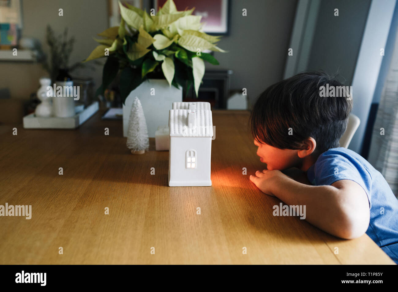 Child looking at holiday light ceramic house Stock Photo