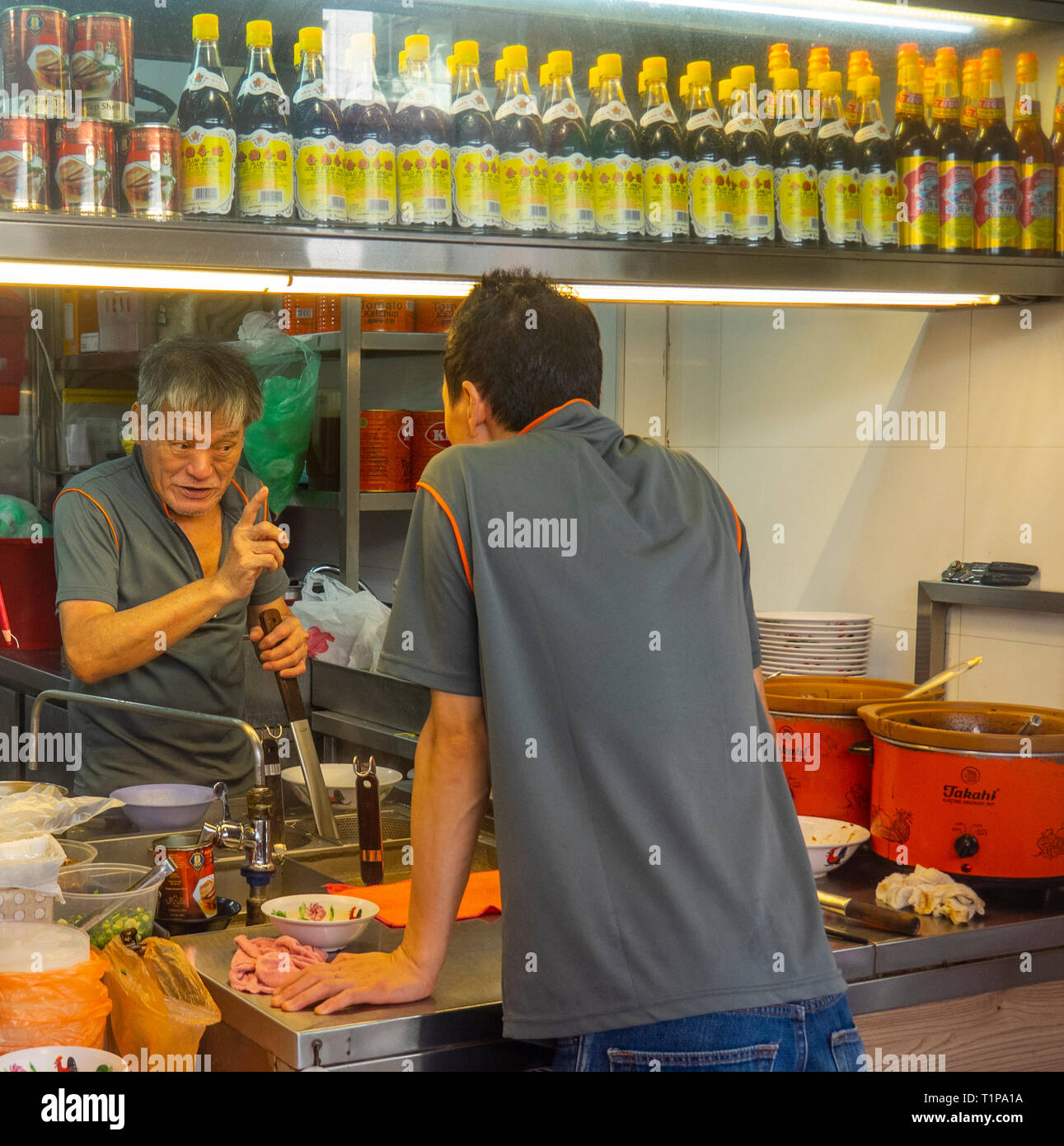 In a restaurant a man giving another man instructions and pointing his finger. Stock Photo