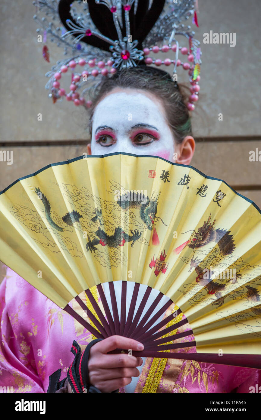 Young woman in costume with dragon fan participating in Chinese New Year Parade in San Francisco, California Stock Photo