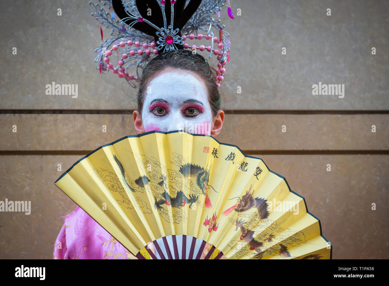 Young woman in costume with dragon fan participating in Chinese New Year Parade in San Francisco, California Stock Photo