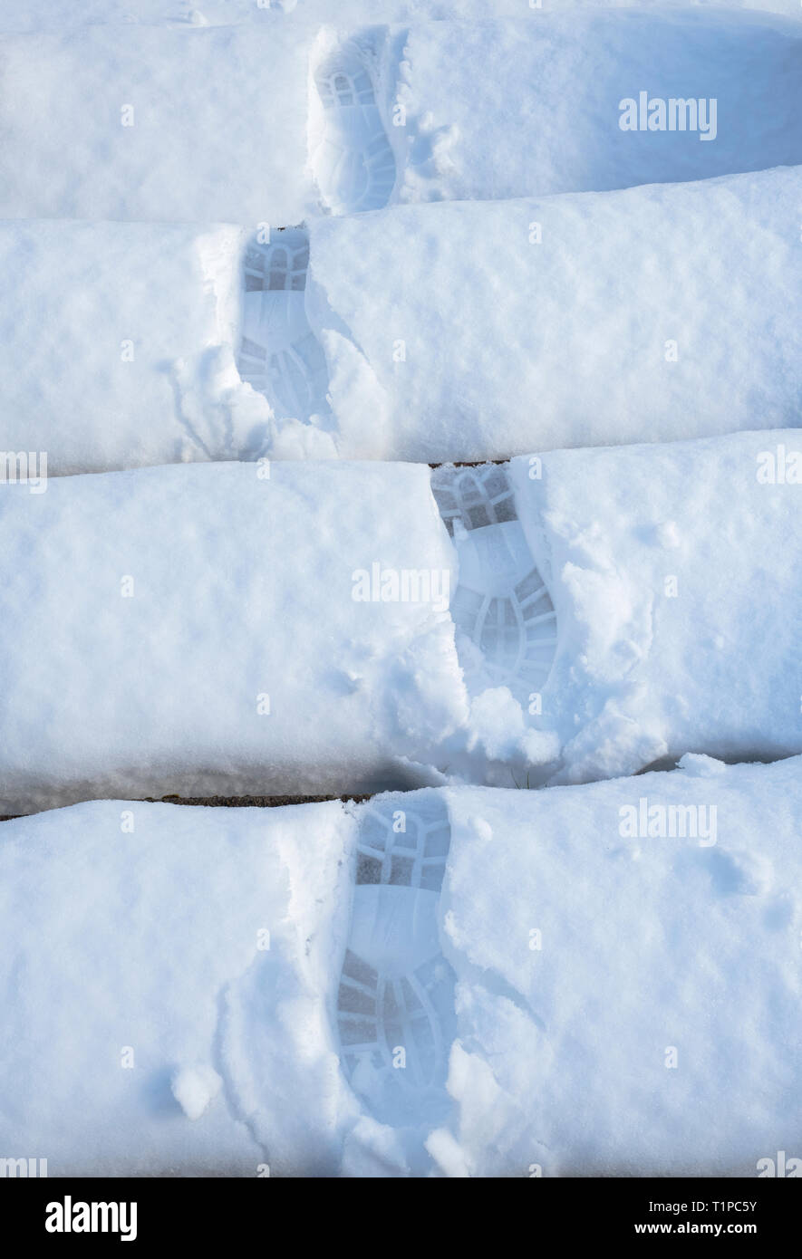 Boot prints on garden stone steps in the snow. Scotland Stock Photo