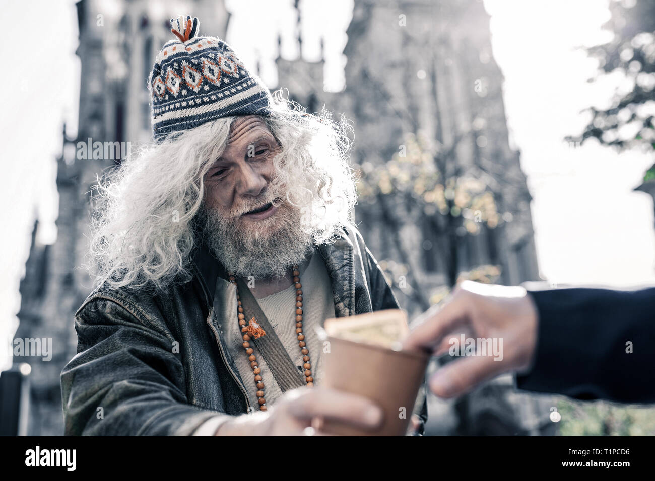 Drunk filthy man living on the street and begging pedestrians Stock Photo