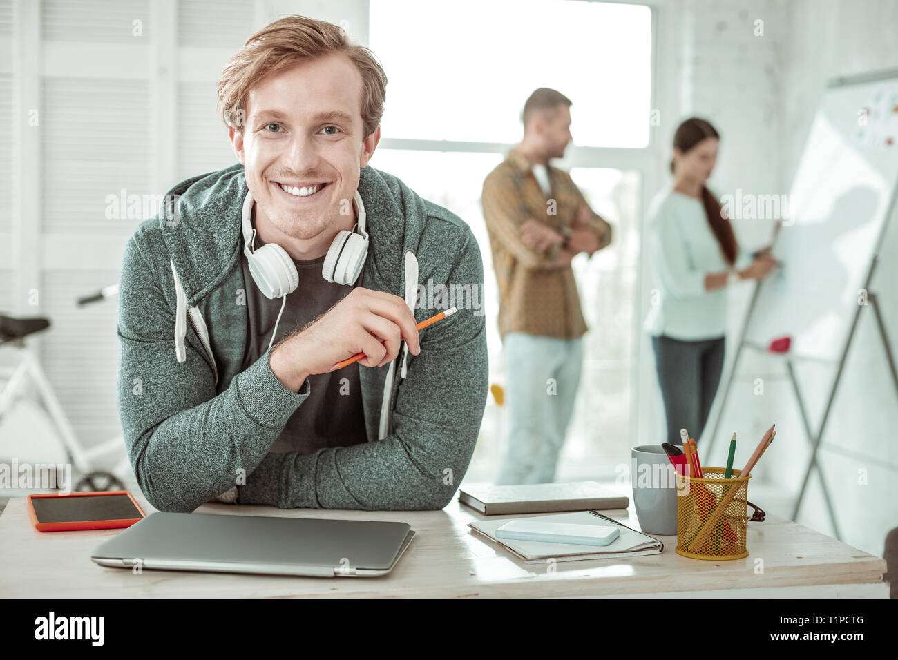 Happy handsome man holding a pencil in his hand Stock Photo
