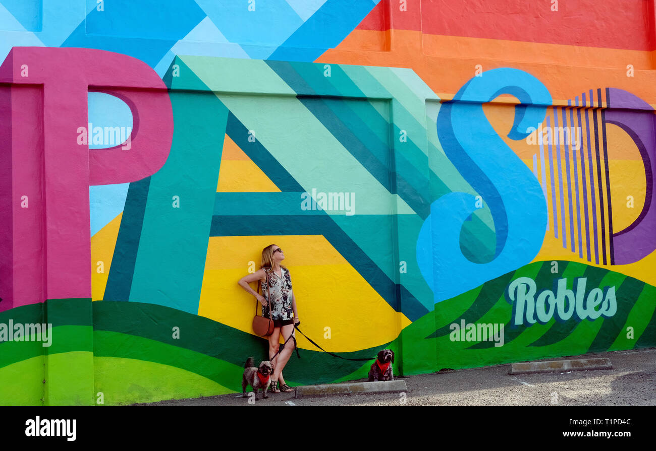 A tourist and her dogs pictured at the Paso Robles mural Stock Photo