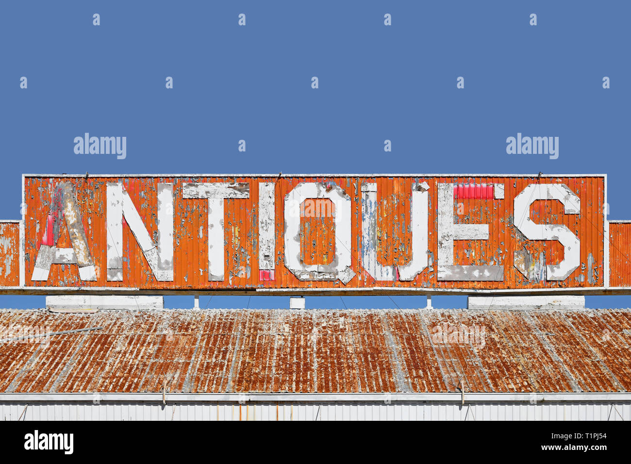 Old Antiques Sign on the Roof of a Closed Antique Store Stock Photo