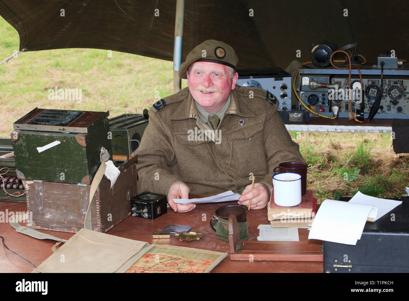 A British war correspondent writing a message in his makeshift office during the D-Day celebrations in Normandy, France Stock Photo