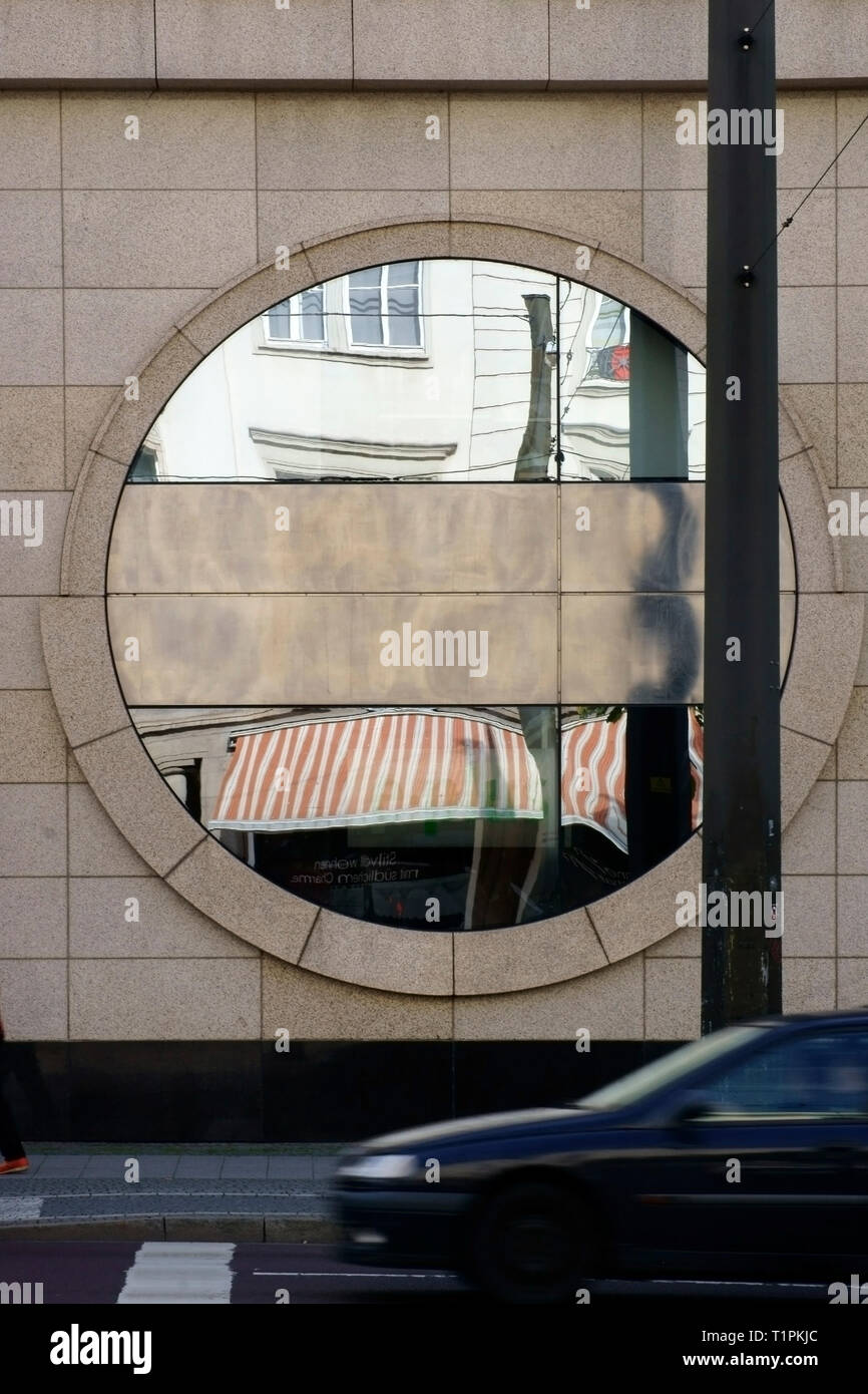 Outside Building Mirror A circular decoration mirror on the exterior facade of a building with ...