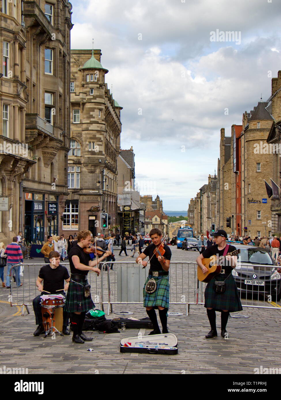 music band dressed in traditional skirts and playing on bagpipes on