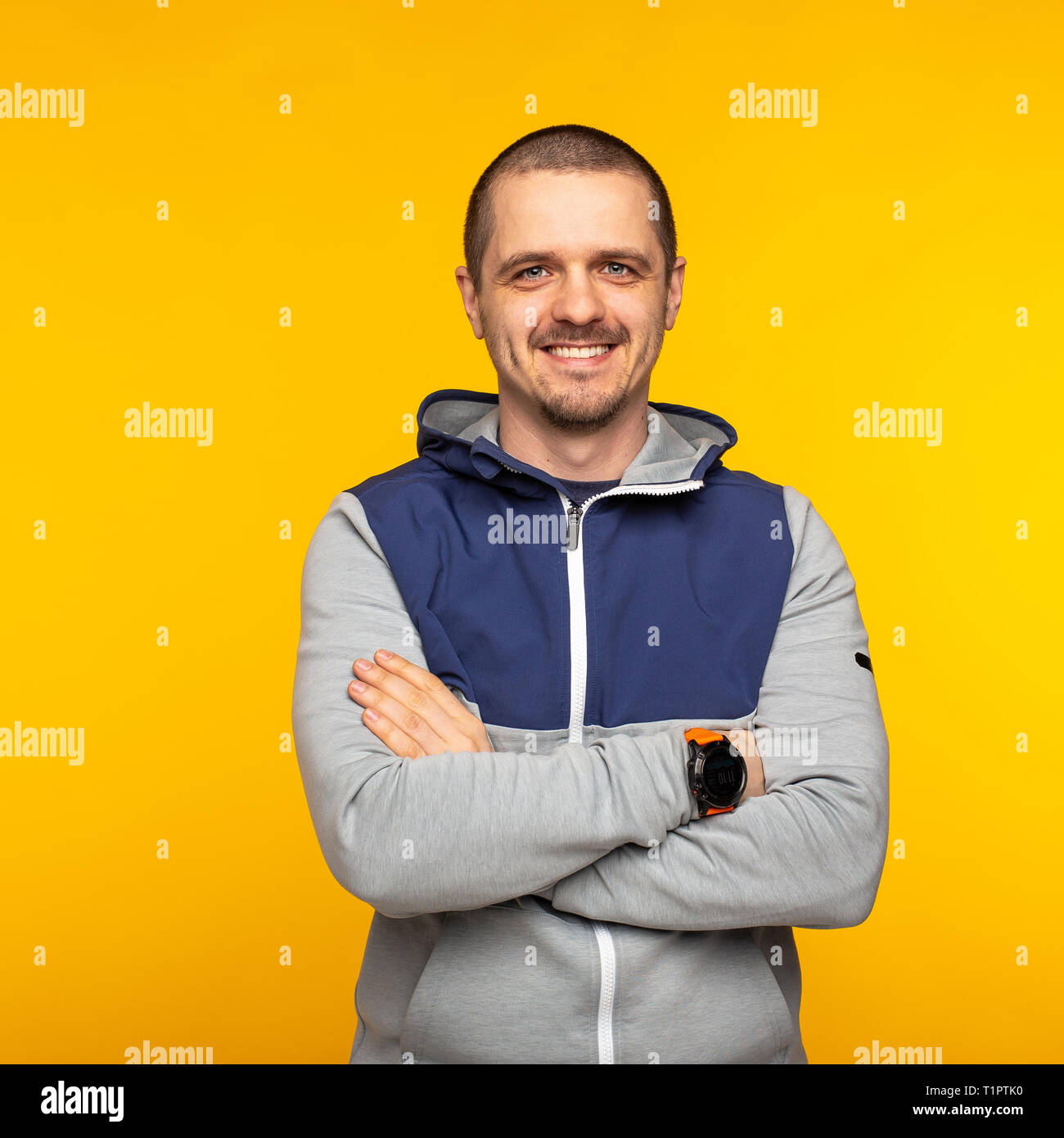 Man standing in hoodie and looking in camera and smiling Stock Photo