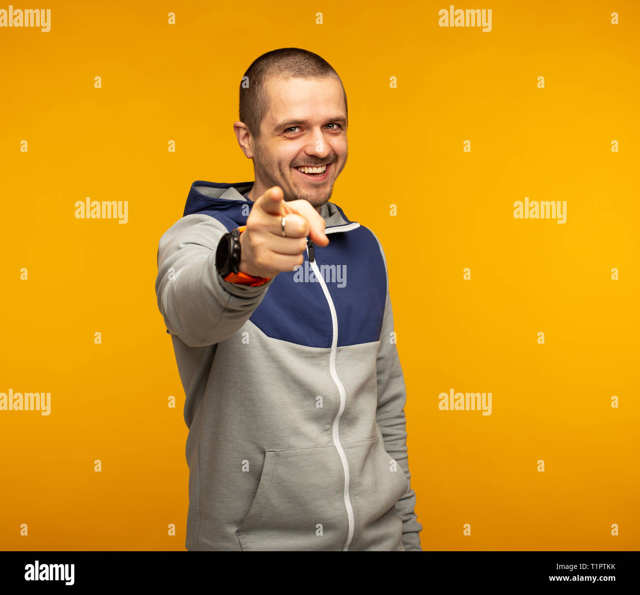 Man in casual wear pointing in camera and smiling Stock Photo