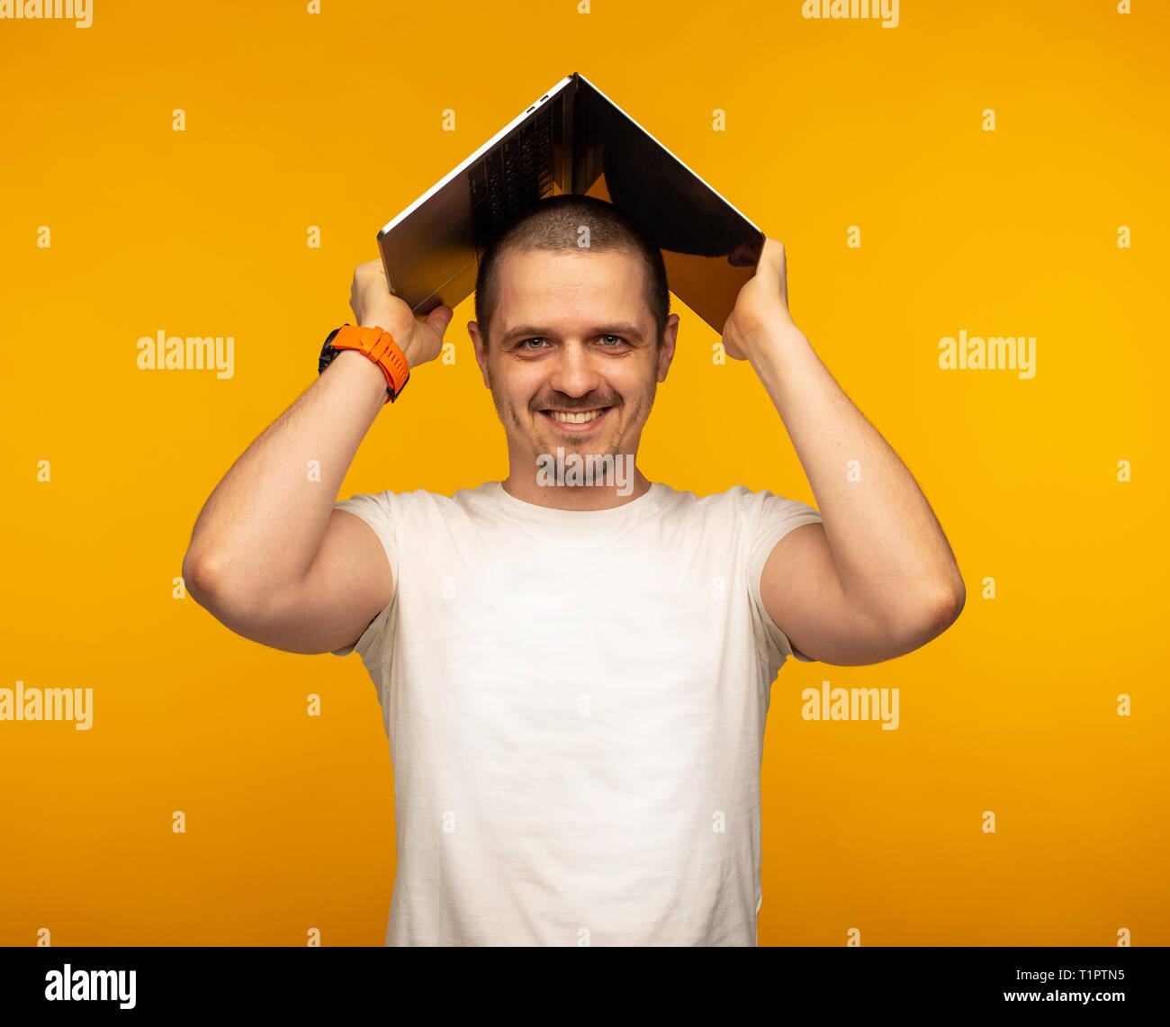 Man freelancer or IT programmer holding laptop over his head Stock Photo