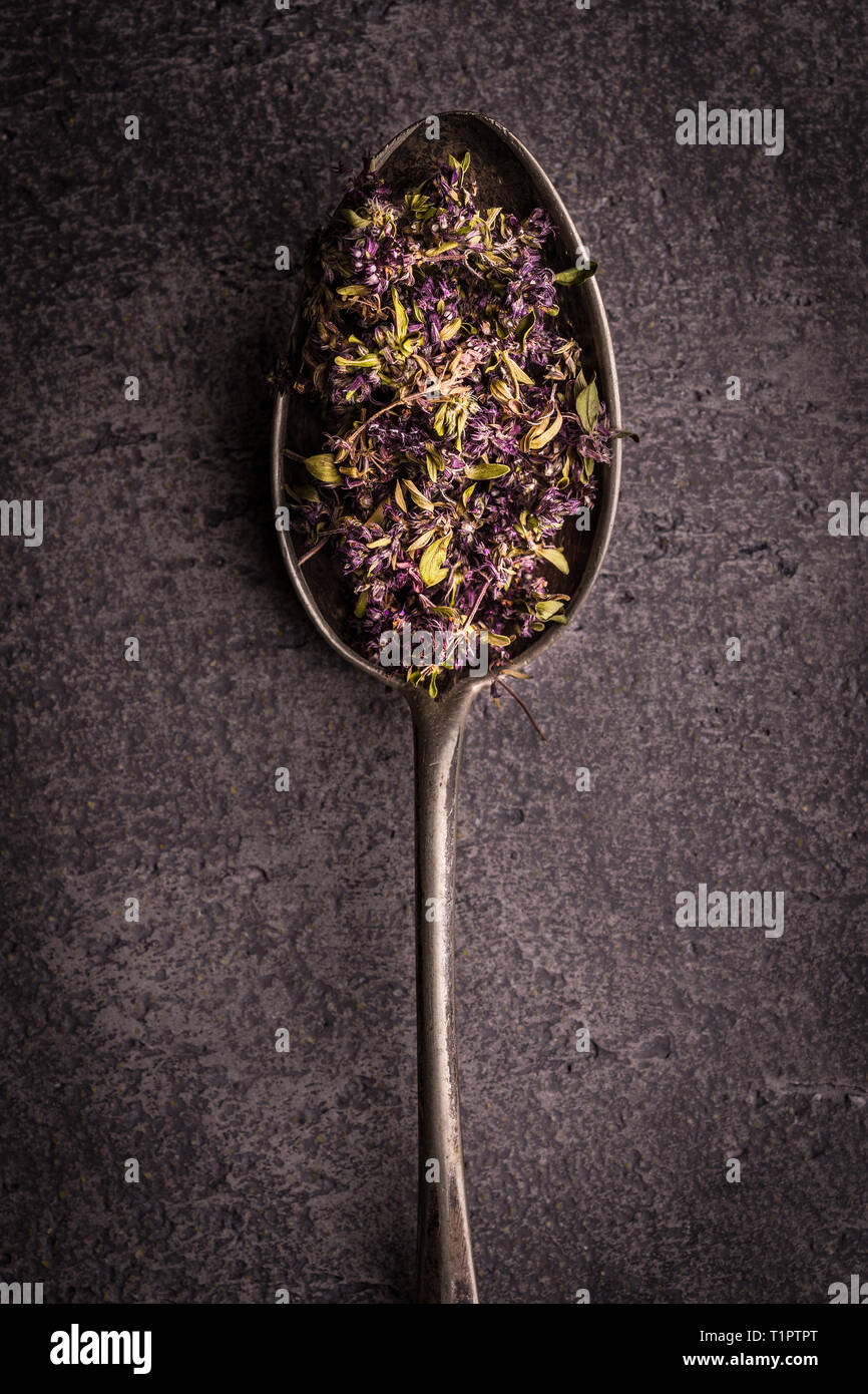 Dry Tea Leafs in Rustic Spoon on Dark Stone Background Stock Photo