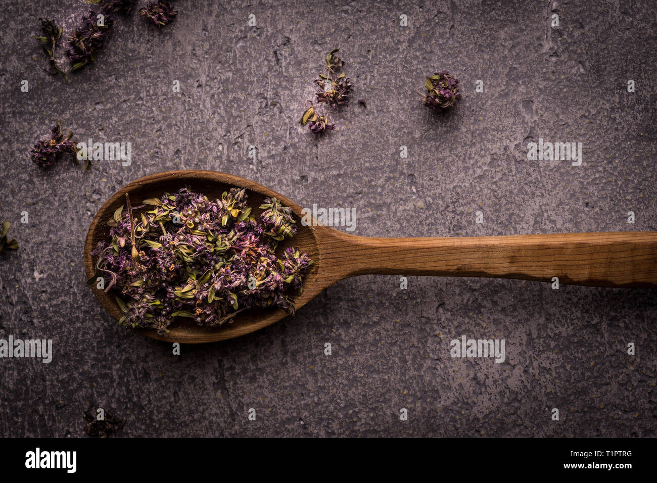 Dry Tea Leafs in Rustic Spoon on Dark Stone Background Stock Photo