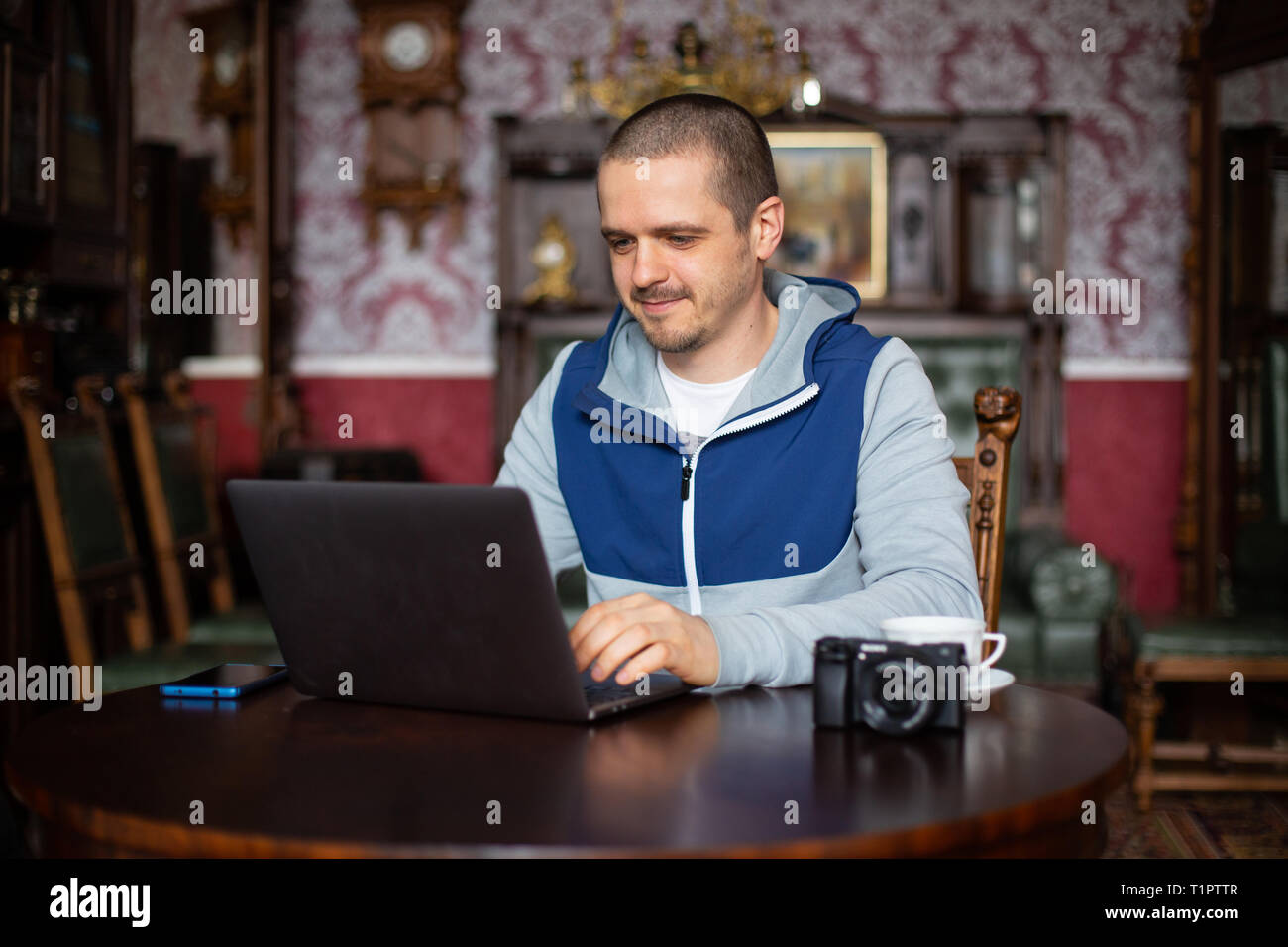 Man freelancer with laptop and camera working Stock Photo