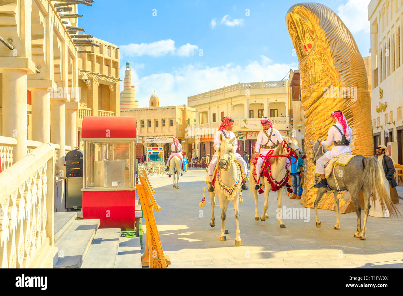 Doha, Qatar - February 20, 2019: police officers, famous attraction, riding white Arabian horses at Souq Waqif. Fanar Islamic Cultural Center with Stock Photo