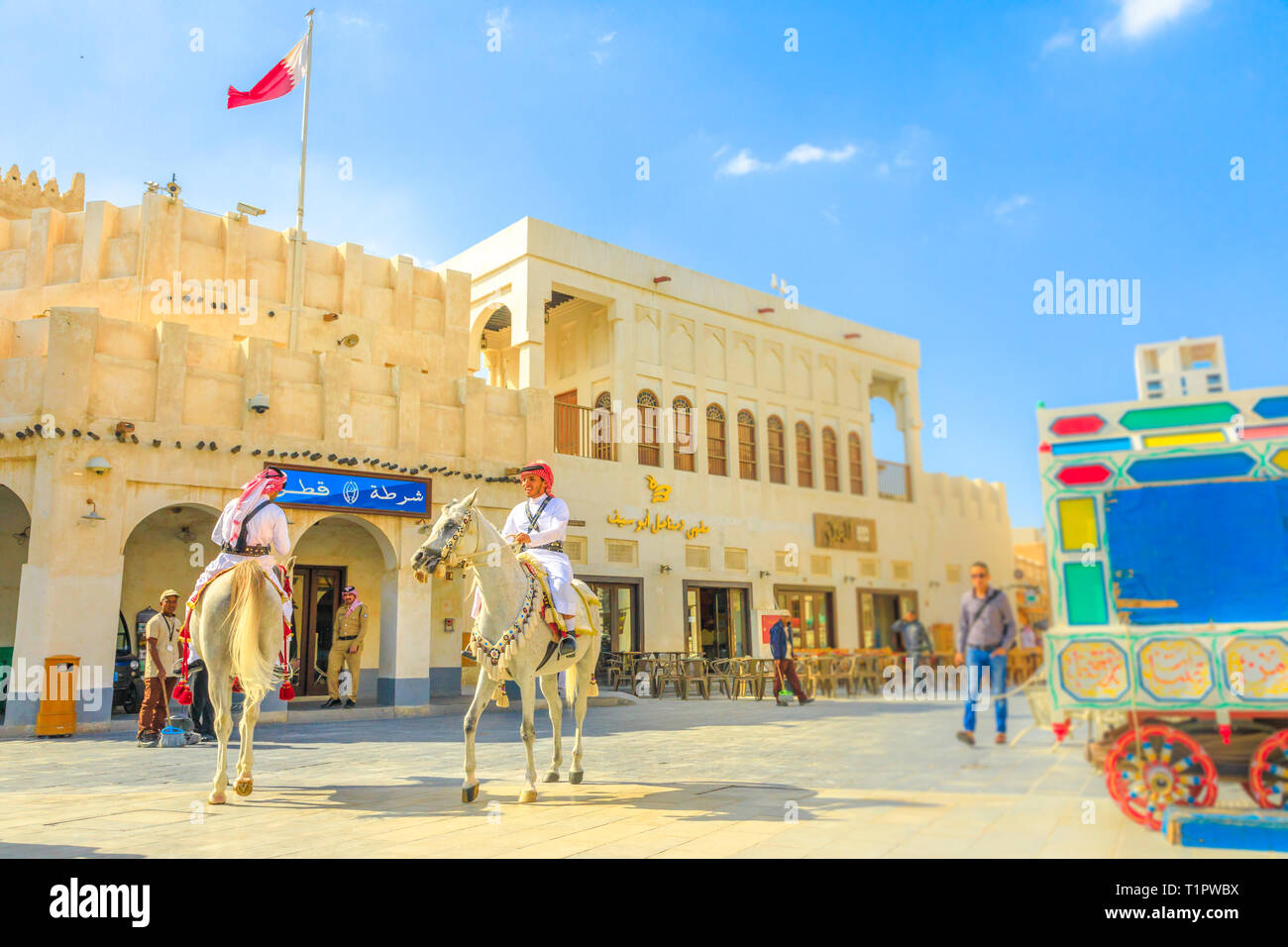 Doha, Qatar - February 20, 2019: Police on horse at Souq Waqif riding white Arabian Horses. Popular tourist attraction in Middle East, Arabian Stock Photo