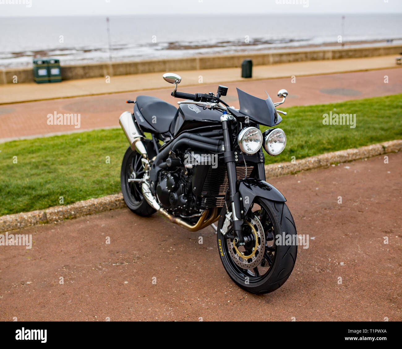 Front end view of a black Triumph Speed Triple motorcycle parked up on